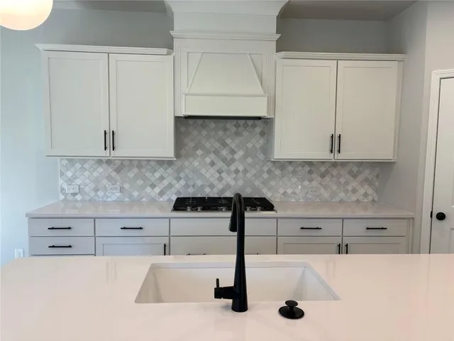 a kitchen with granite countertop white cabinets and white appliances