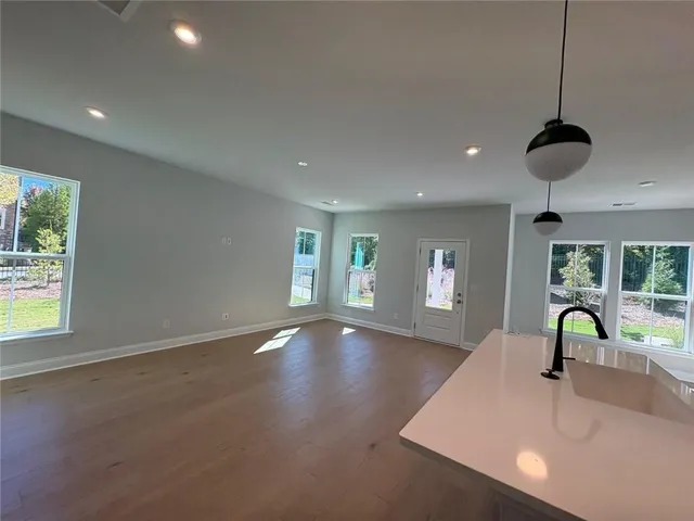 a view of empty room with wooden floor and window