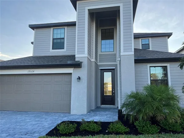 a front view of a house with plants