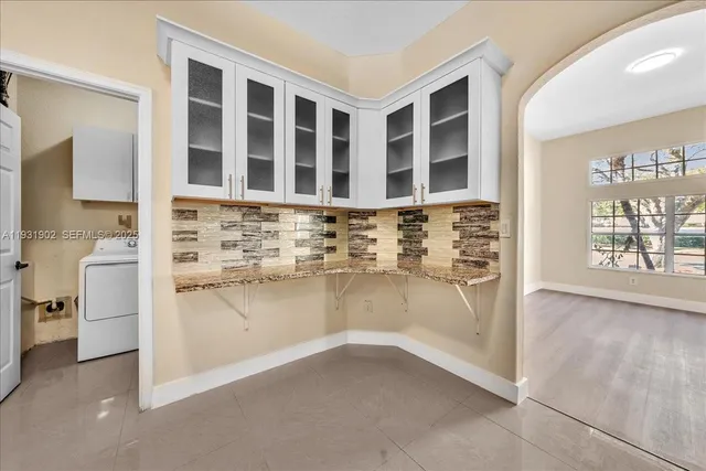 a view of an empty room with wooden floor and a ceiling fan