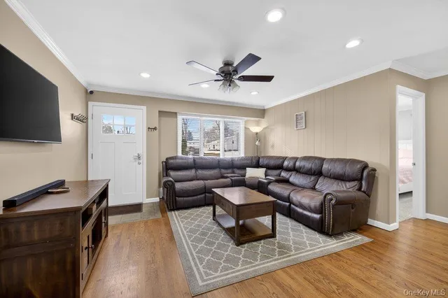 a living room with furniture a flat screen tv and a window