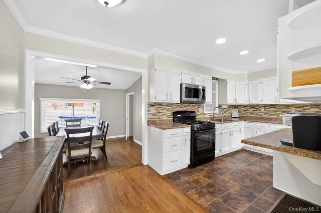 a kitchen with a dining table chairs cabinets and stainless steel appliances