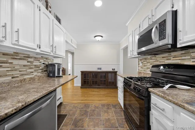 a kitchen with stainless steel appliances granite countertop a stove a sink and a microwave