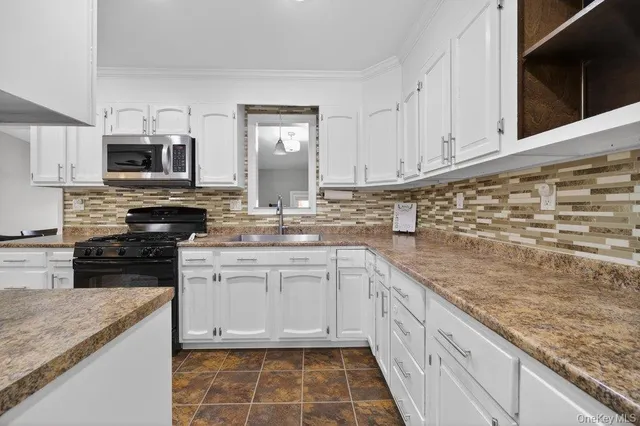 a kitchen with stainless steel appliances granite countertop a sink stove and cabinets