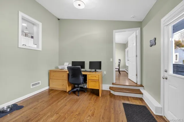 a view of a workspace with furniture and wooden floor