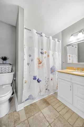 a bathroom with a granite countertop sink a toilet and a bathtub
