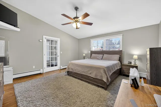 a spacious bedroom with a bed a window and a flat screen television