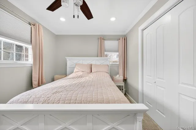 a bedroom with a large bed and a chandelier fan