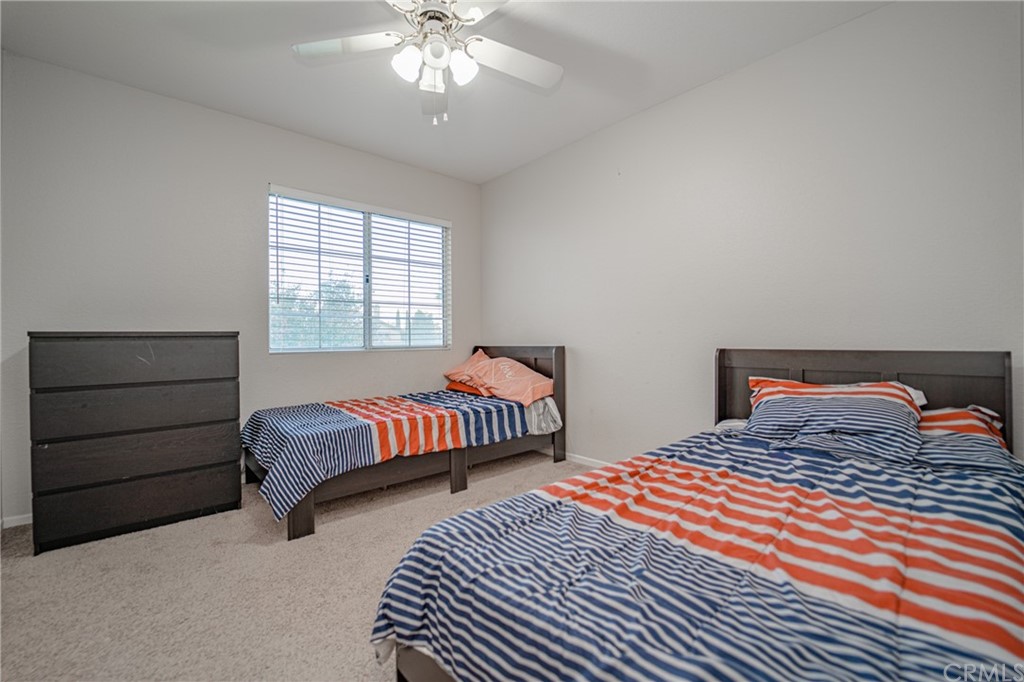 2810 Athens Circle Corona, CA 92882 - Photo 27 of 34 a bedroom with two beds and a chandelier
