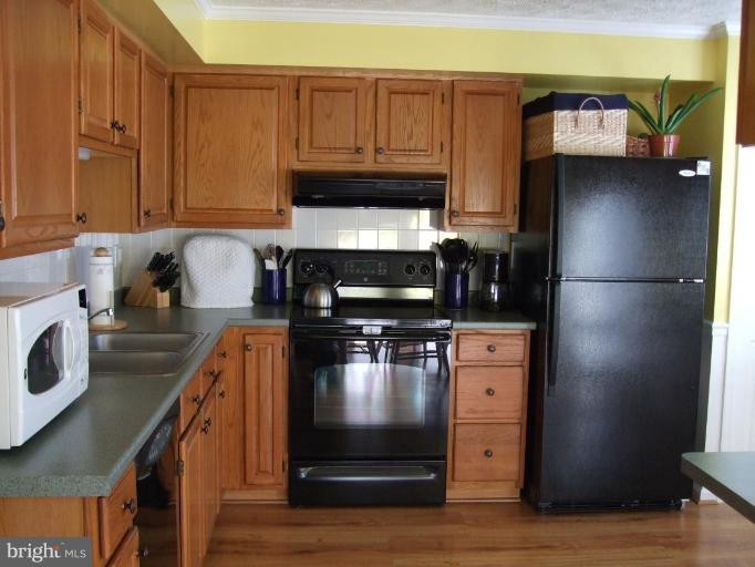 111 Cross Ridge Court Stafford, VA 22554 - Photo 2 of 23 a kitchen with granite countertop a refrigerator stove and wooden cabinets