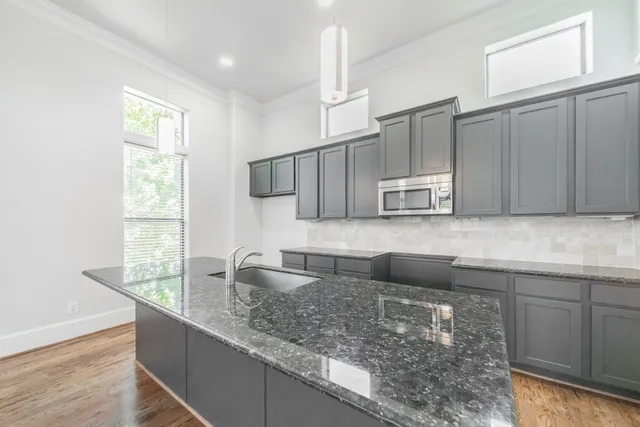 a kitchen with stainless steel appliances granite countertop a sink a microwave and wooden cabinets