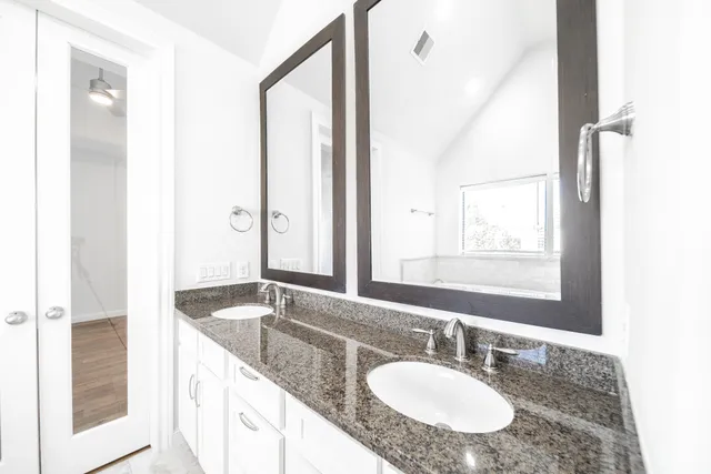 a bathroom with a granite countertop sink and a mirror