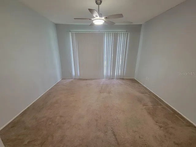 en empty room with windows and fan