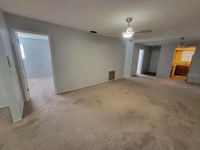 a view of a livingroom with a ceiling fan and window