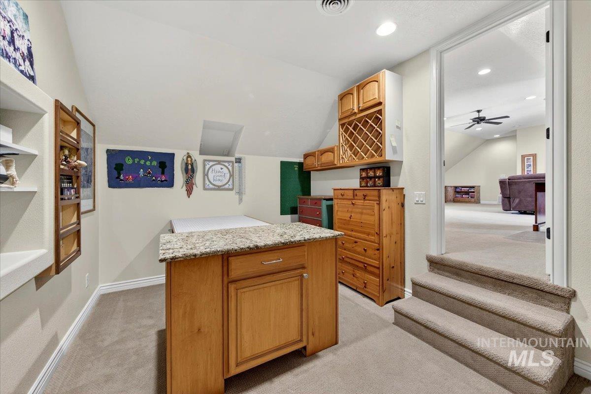 414 East Shafer View Drive Meridian, ID 83642 - Photo 34 of 50 Carpeted room with a central wood-finish island featuring a light-toned granite countertop and integrated cabinetry - Perfect space for those ongoing sewing & craft projects!