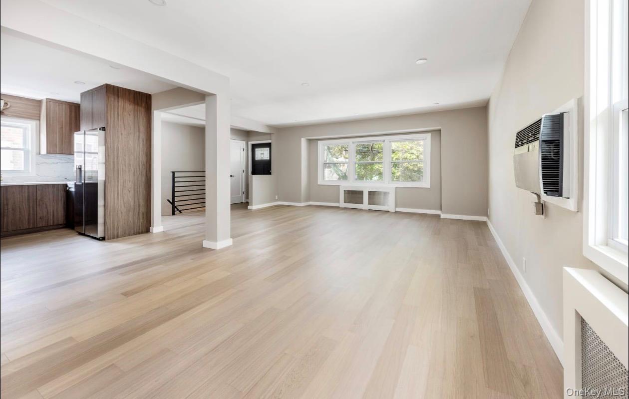208-12 53rd Avenue Queens, NY 11364 - Photo 3 of 11 a view of an empty room with wooden floor and a window