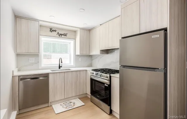 a kitchen with a refrigerator sink and cabinets