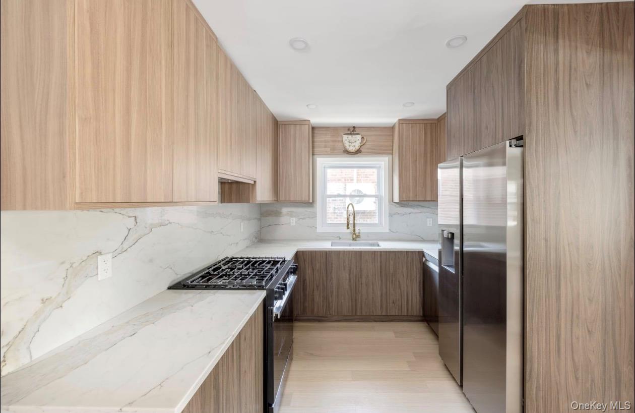 208-12 53rd Avenue Queens, NY 11364 - Photo 6 of 11 a kitchen with a sink stove and refrigerator