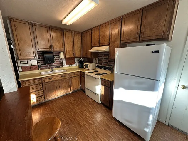 a kitchen with a sink a microwave a refrigerator and cabinets