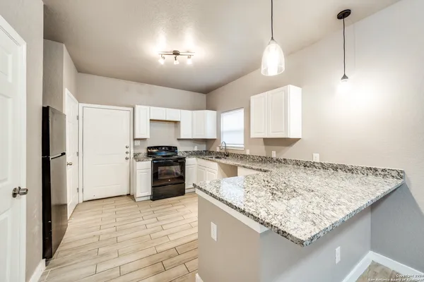 a kitchen with stainless steel appliances granite countertop a sink a stove and a refrigerator
