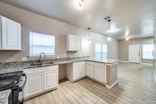 a kitchen with granite countertop cabinets stainless steel appliances a sink and a counter top space