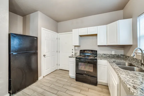 a kitchen with a stove sink and refrigerator