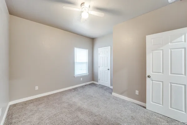 an empty room with chandelier fan