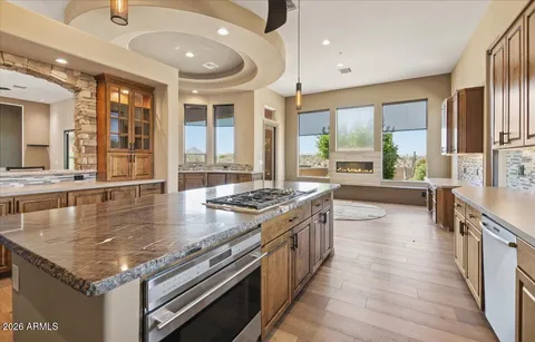 a large kitchen with stainless steel appliances a large counter top a stove a chimney a sink and a large window