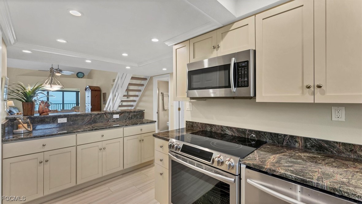 2700 North Beach Road, Unit B205 Englewood, FL 34223 - Photo 17 of 47 a kitchen with granite countertop white cabinets and stainless steel appliances