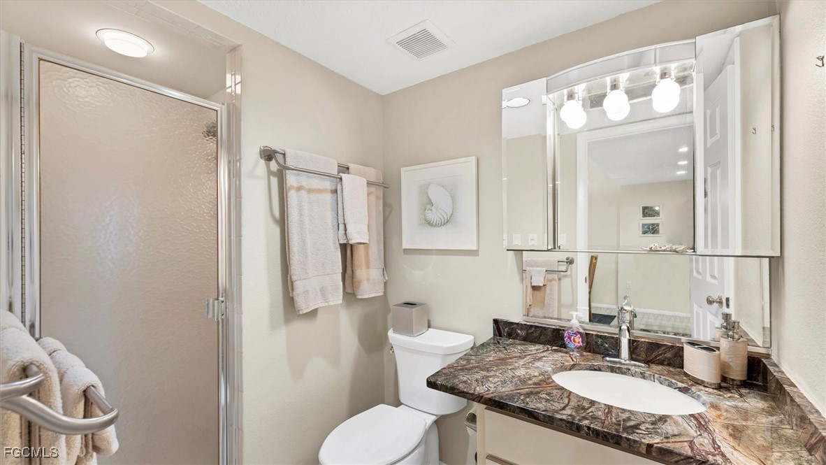 2700 North Beach Road, Unit B205 Englewood, FL 34223 - Photo 30 of 47 a bathroom with a granite countertop sink toilet and shower