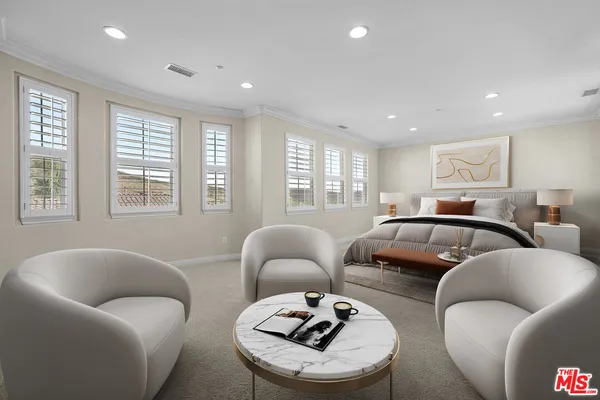 a bedroom with furniture and a large window