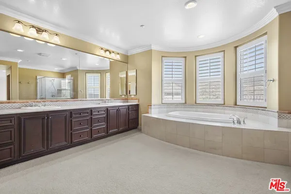 a spacious bathroom with a large tub sink and mirror