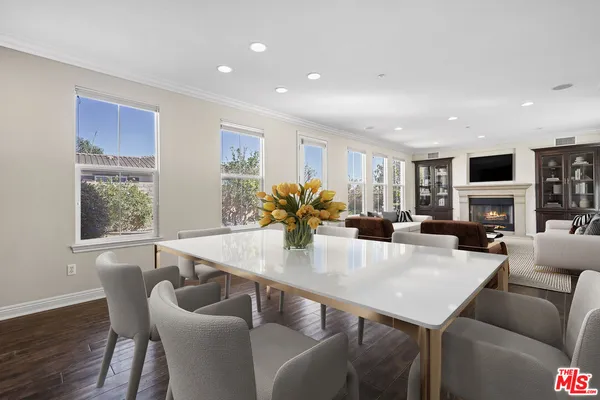 a view of a dining room with furniture a fireplace and wooden floor