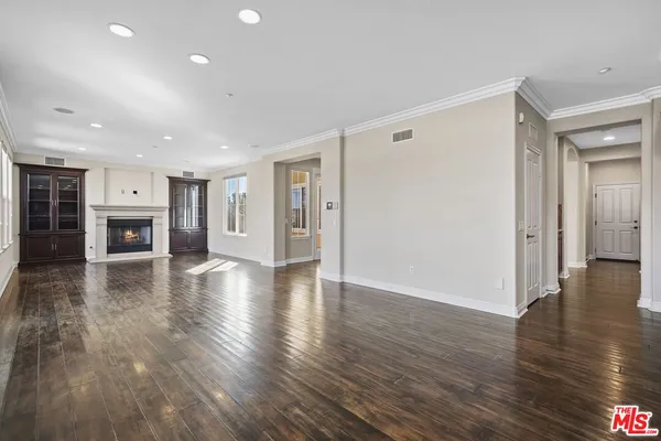 a view of a livingroom with furniture wooden floor ceiling fan and kitchen view