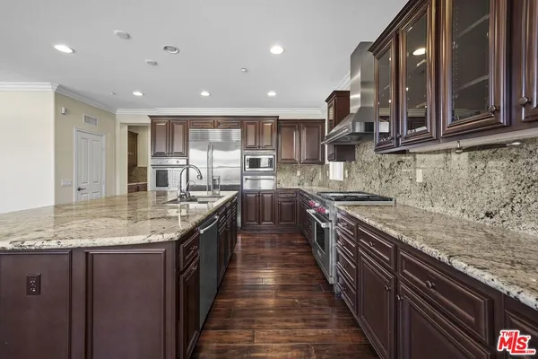 a kitchen with stainless steel appliances granite countertop sink stove and oven