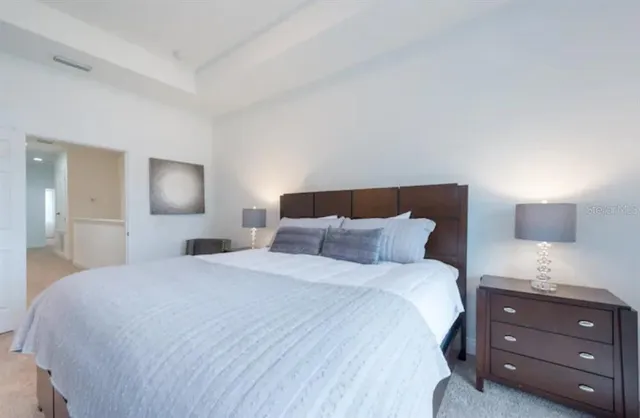 a bedroom with a bed and a night stand