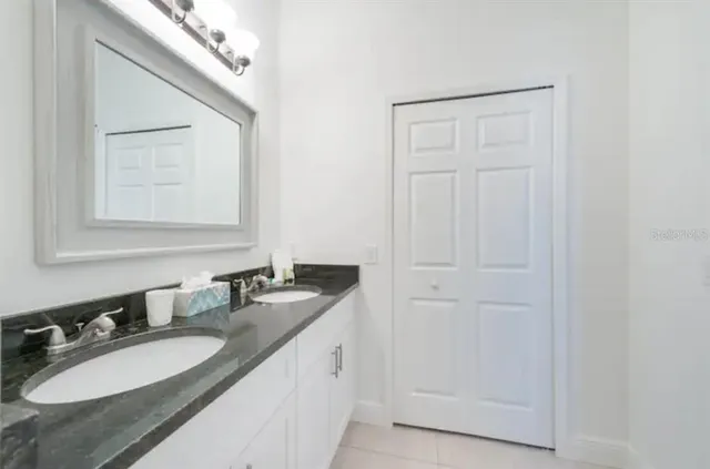 a bathroom with a granite countertop sink and a mirror