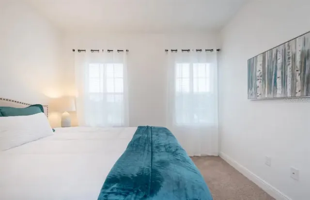 a view of a bedroom with closet and windows