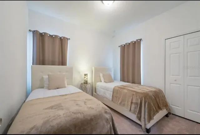 a bedroom with two beds and painting on the wall