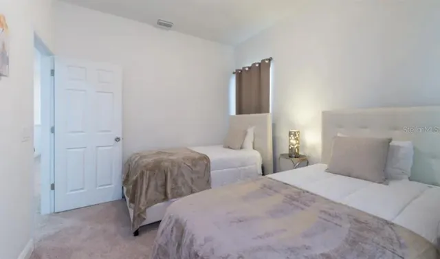 a bedroom with two beds and a lamp