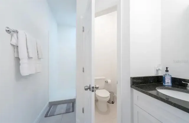 a bathroom with a granite countertop sink a toilet and a shower