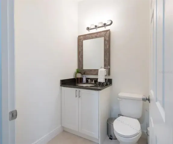 a bathroom with a toilet a sink and mirror