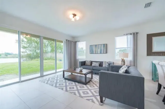 a living room with furniture and a floor to ceiling window