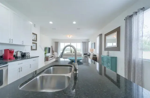 a kitchen with sink a refrigerator and cabinets