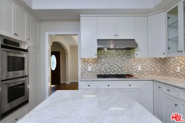 a kitchen with white cabinets stainless steel appliances and sink