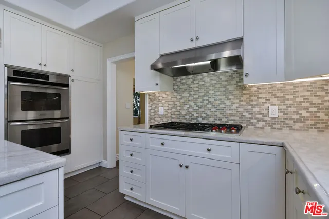 a view of an empty room with wooden floor fireplace and a window