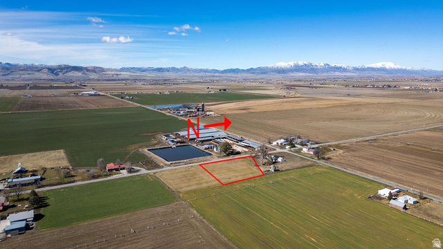 750 North Main Street Lewiston, UT 84320 - Photo 2 of 9 Expansive agricultural land parcel with clear boundaries, bordering a farm operation featuring multiple structures and a pond