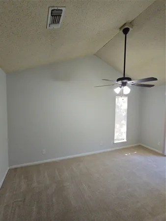 an empty room with windows and fan