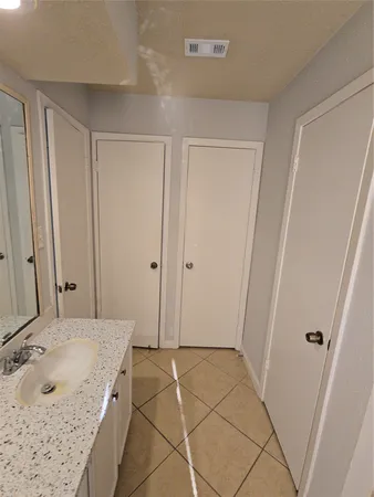 a bathroom with a granite countertop sink and a mirror