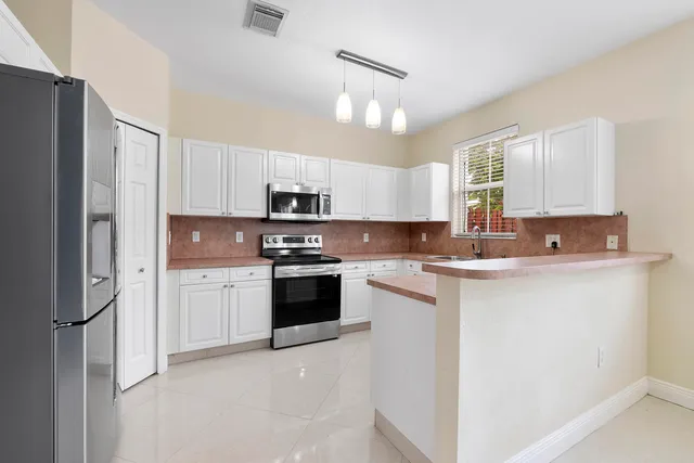 a kitchen with stainless steel appliances a refrigerator sink and microwave